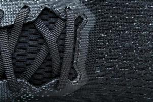 Mesh of black sports sneakers for training Macro photo