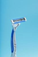 Shaving machine with three blades on a blue background close-up free space photo