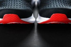 Black sports sneakers with red soles on a black background. photo