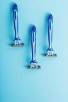 Blue shaving machines in a row on a blue background photo