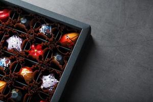 Handmade chocolates in a box on a dark background. photo