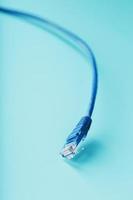 Blue Ethernet Cable Cord Patch cord on a blue background with free space photo