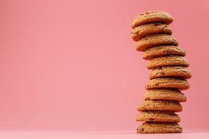 Oatmeal cookies stacked on a pink background. photo
