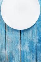 White plate on a blue background top view. photo