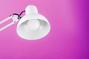 White table office lamp on pink background with space for text and idea concept photo