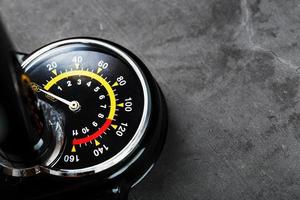 Air pump manometer for monitoring tire pressure on a dark background with free space photo