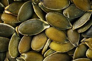 Macro background texture of green pumpkin seeds photo