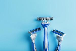 Blue shaving machines in a row on a blue background with ice cubes photo