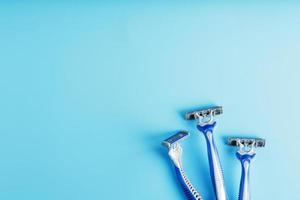 Blue shaving machines in a row on a blue background with ice cubes photo