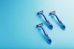 Blue shaving machines in a row on a blue background with ice cubes photo