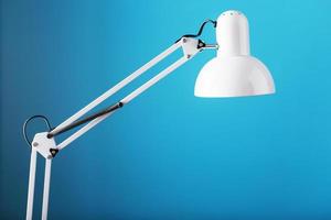 Office table lamp on blue background with space for text and idea concept photo