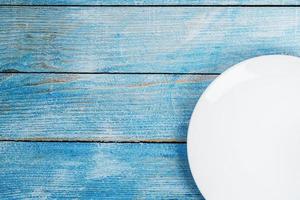 Empty round bowl on a blue wooden background from above photo