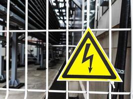 Danger Sign High voltage in a yellow triangle on a metal grid photo