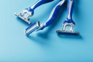 Blue shaving machines in a row on a blue background photo