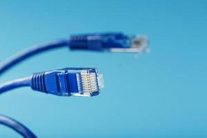 Ethernet Cable connector Patch cord cord close-up on a blue background with free space photo