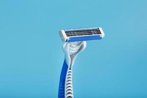 Razor blades on a blue background with drops of icy water photo