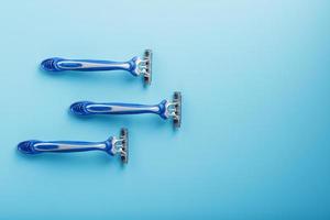 Blue shaving machines in a row on a blue background with ice cubes photo