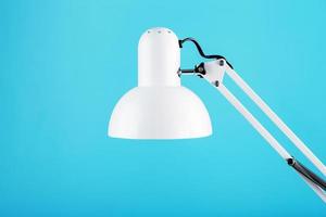 Office table lamp on blue background with space for text and idea concept photo