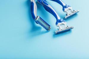 Blue shaving machines in a row on a blue background with ice cubes photo