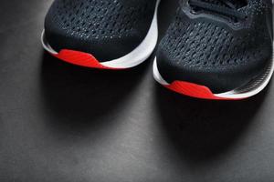 Black running shoes with mesh and black laces close-up on a dark background photo