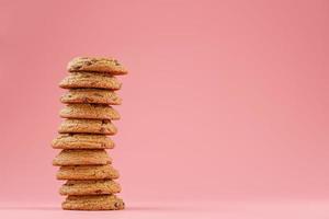 Oatmeal cookies stacked on a pink background. photo