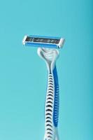 cuchillas de una nueva máquina de afeitar sobre un fondo azul foto