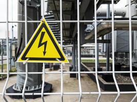 Danger Sign High voltage in a yellow triangle on a metal grid photo