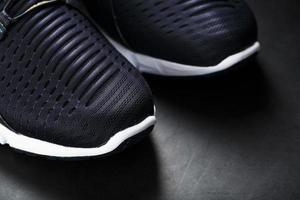 zapatillas deportivas ultramodernas en blanco y negro sobre fondo negro. foto