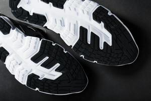 The black and white sole of trendy sports sneakers is a close-up in full screen. photo