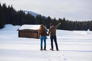 pareja divirtiéndose y caminando con raquetas de nieve foto