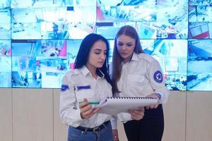 Female security guards working in a security data system control room photo