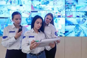 Female security guards working in a security data system control room photo