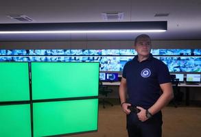 portrait of young male security operator in a data system control room photo