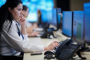 Female operator working in a security data system control room photo