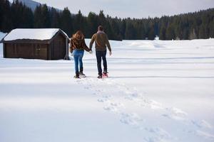 couple having fun and walking in snow shoes photo