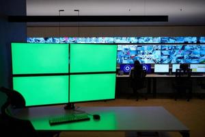 Empty interior of big modern security system control room with blank green screens photo