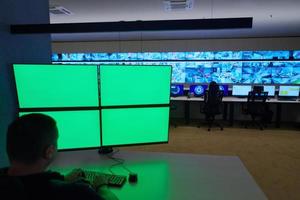 male security operator working in a data system control room photo