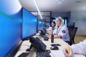 Female security guards working in a security data system control room photo