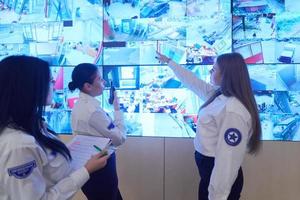 Female security guards working in a security data system control room photo