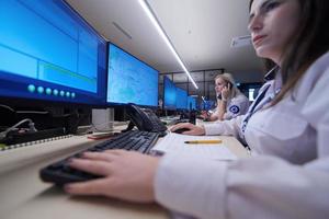 Female security guards working in a security data system control room photo