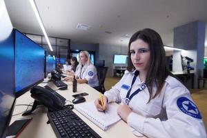 Female security guards working in a security data system control room photo