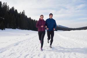 couple jogging outside on snow photo