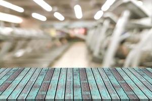 Empty wooden board space platform with blur fitness gym equipment background photo