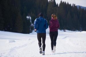 couple jogging outside on snow photo