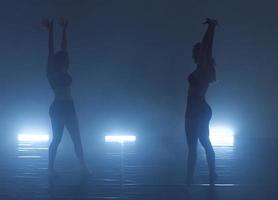 couple of female athletic dance partners in a dark environment photo