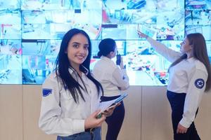 Female security guards working in a security data system control room photo