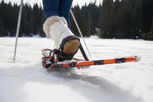 pareja divirtiéndose y caminando con raquetas de nieve foto