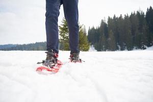 pareja divirtiéndose y caminando con raquetas de nieve foto