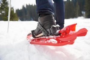 pareja divirtiéndose y caminando con raquetas de nieve foto