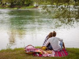 Couple taking a selfie by mobile phone while enjoying picnic time photo